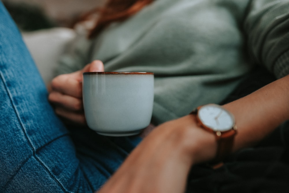 person holding white ceramic mug