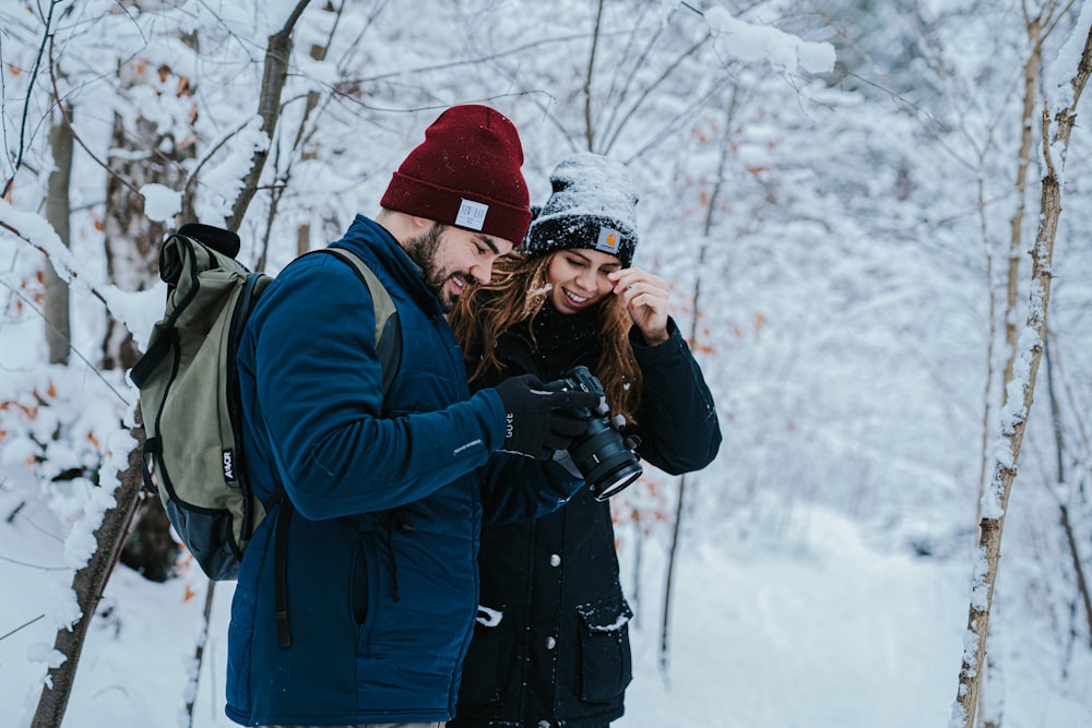 woman in black jacket taking photo of snow covered ground