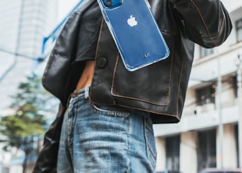 woman in black leather jacket holding blue iphone case