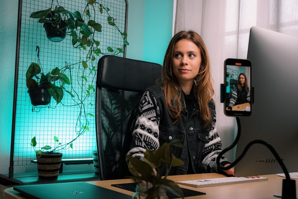 Femme en noir et blanc veste zippée assise sur une chaise roulante de bureau noire