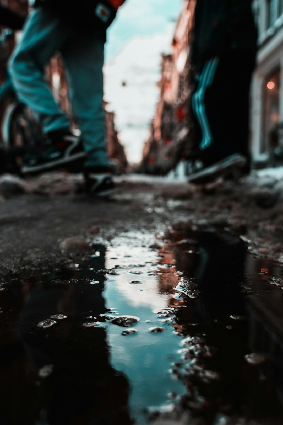 person in blue denim jeans standing on brown soil