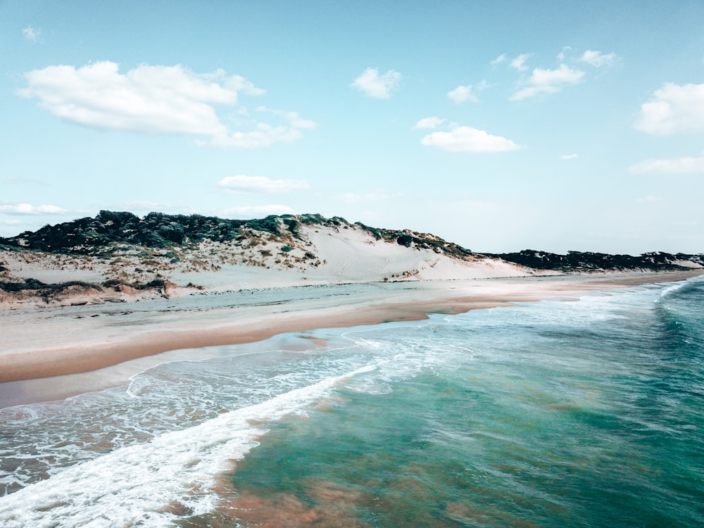 sea waves crashing on shore during daytime