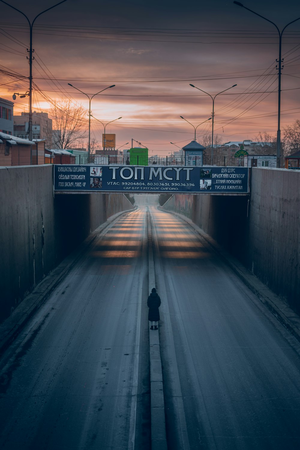 person in black jacket walking on sidewalk during daytime