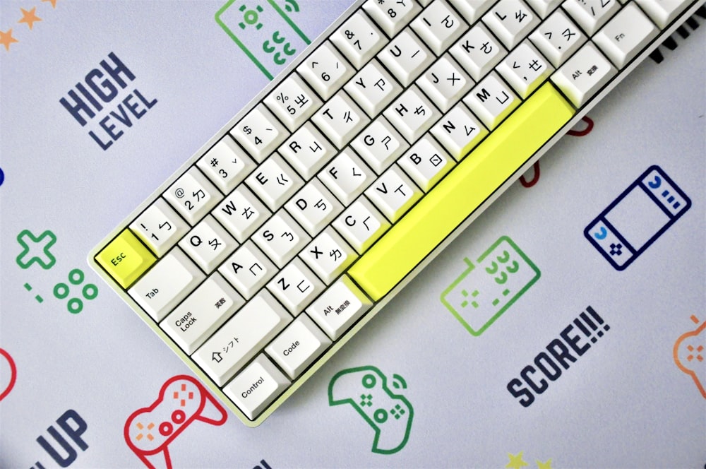 teclado amarelo e branco na superfície azul e branca