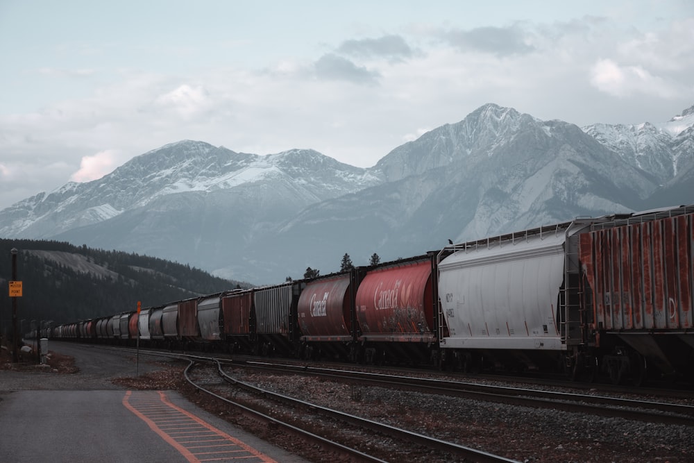 昼間の鉄道を走る赤と灰色の列車