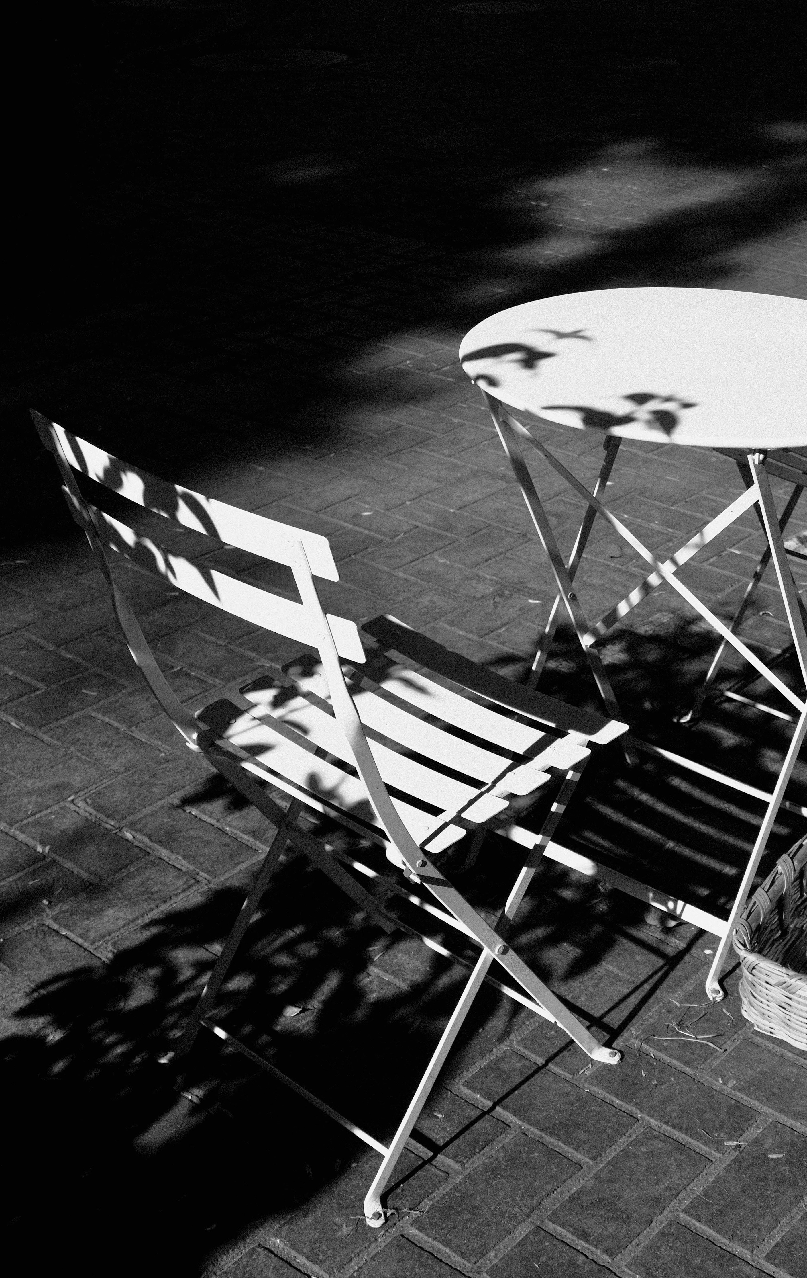 grayscale photo of white wooden folding chairs