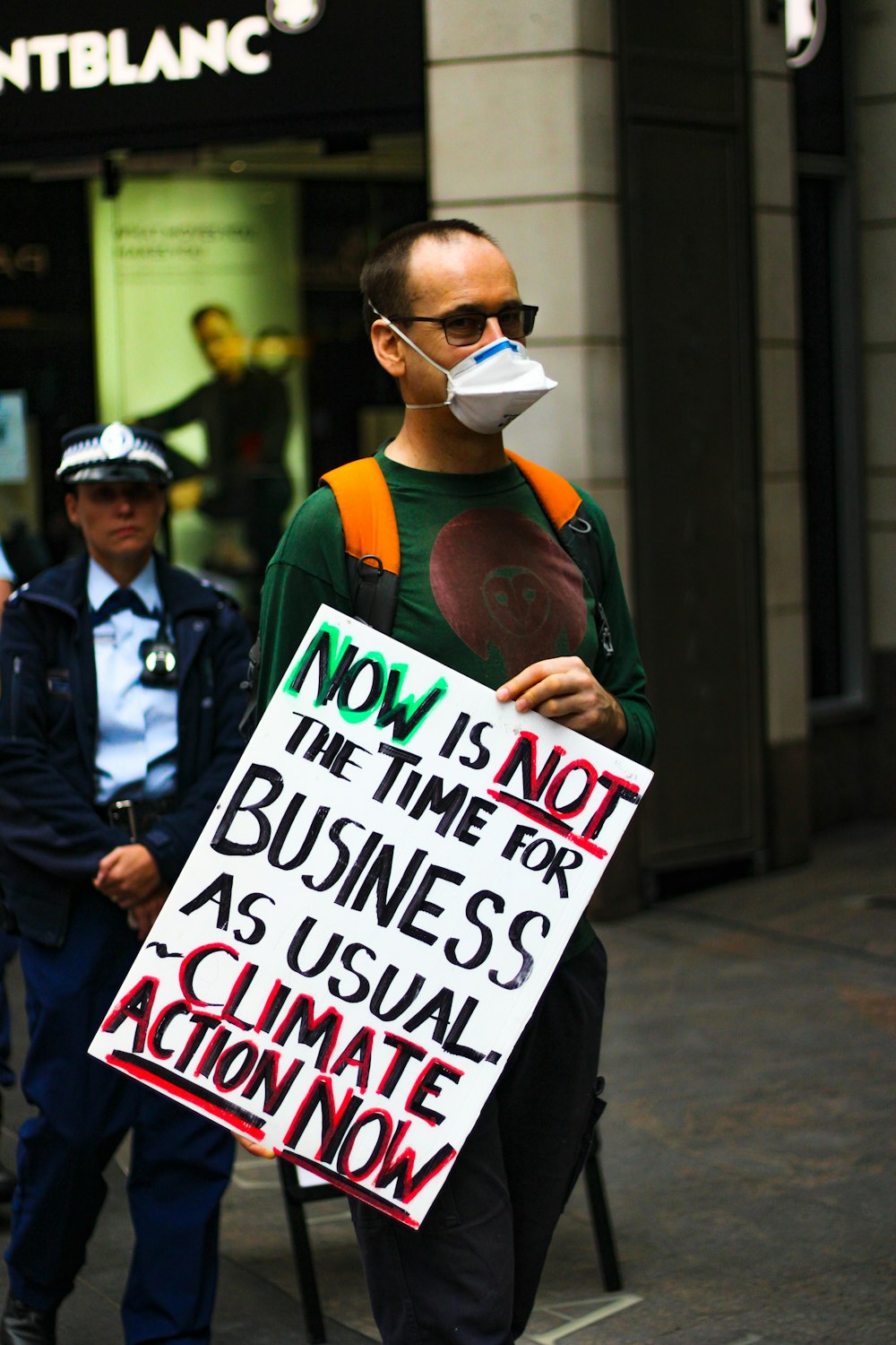 man in black jacket holding white and black signage