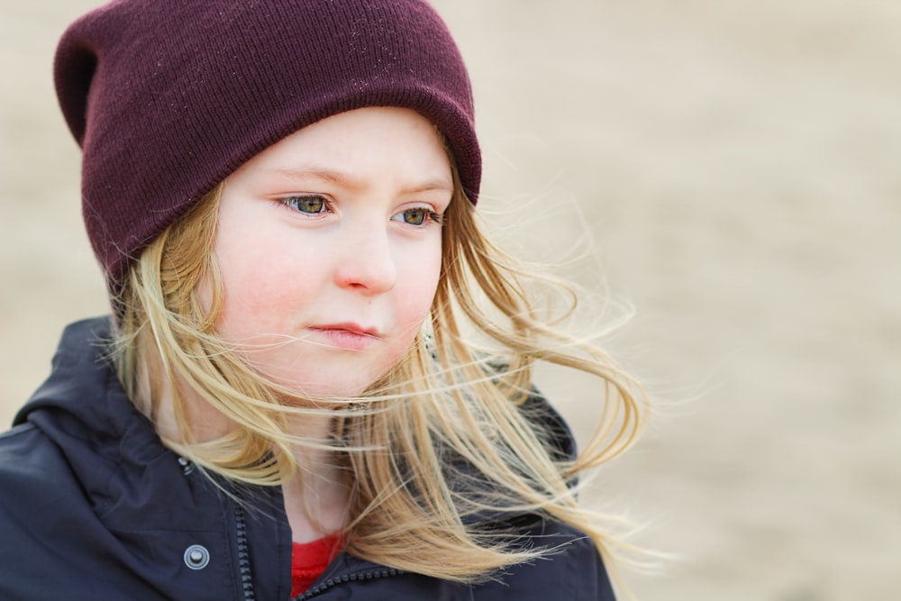 girl in red knit cap and black jacket