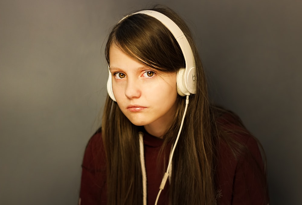 woman in red long sleeve shirt wearing white headphones