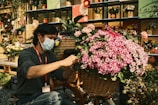 A smiling housekeeper arranging flowers in a bright space.
