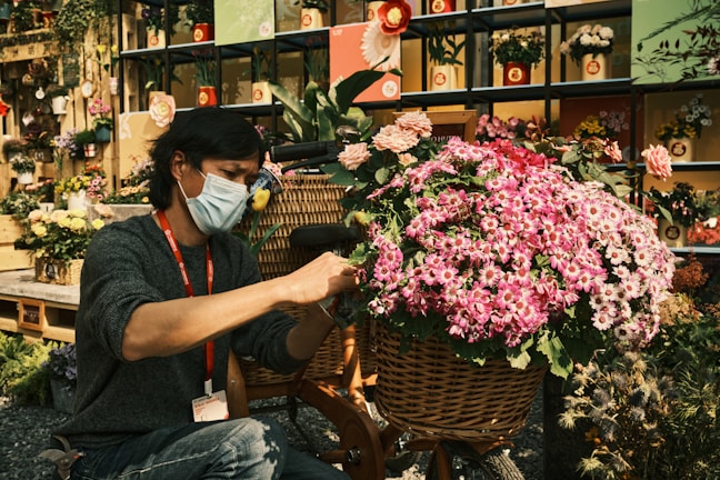 A smiling housekeeper arranging flowers in a bright space.