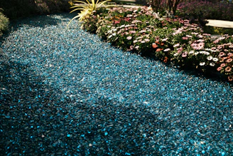 A pathway made with sparkling broken marble pieces winding through a green garden.