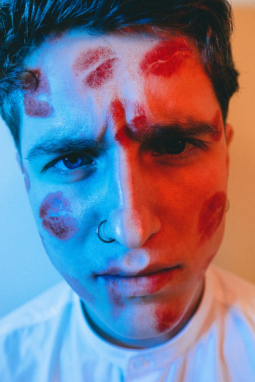 man in white shirt with blue paint on face