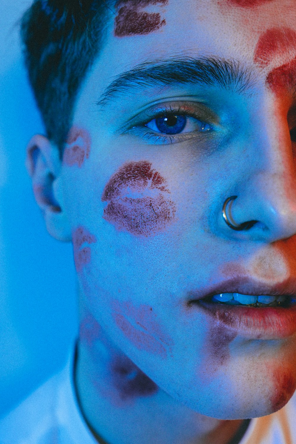 man with blue eyes and black ink on face