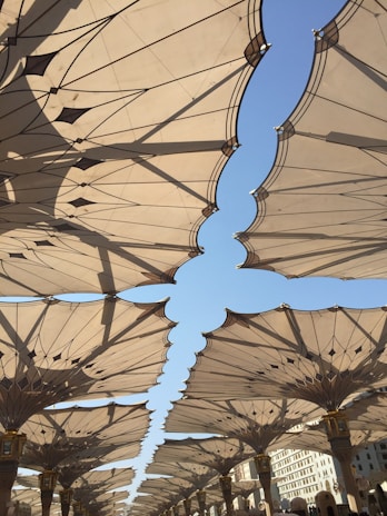 Metallic umbrella structure shading a modern outdoor seating area.