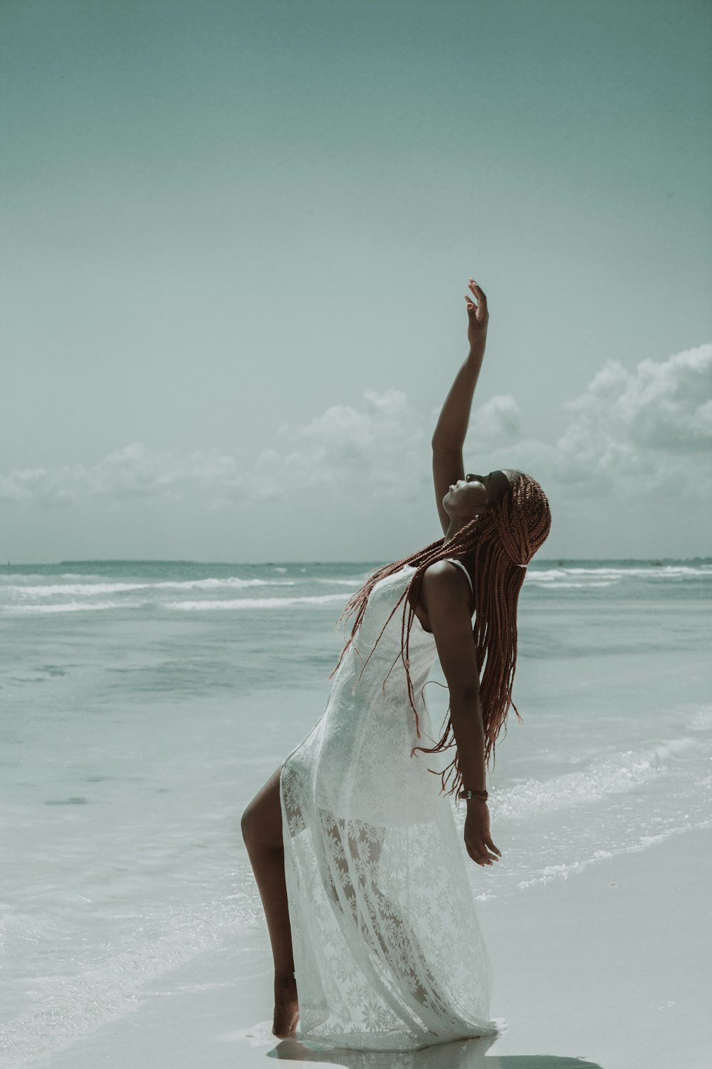 woman in white dress standing on beach during daytime