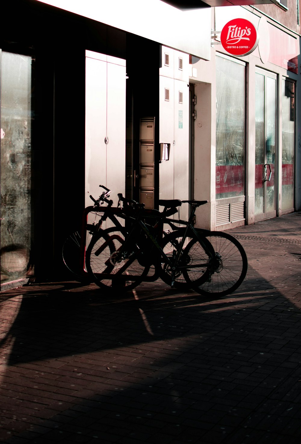 black bicycle parked beside white wooden door