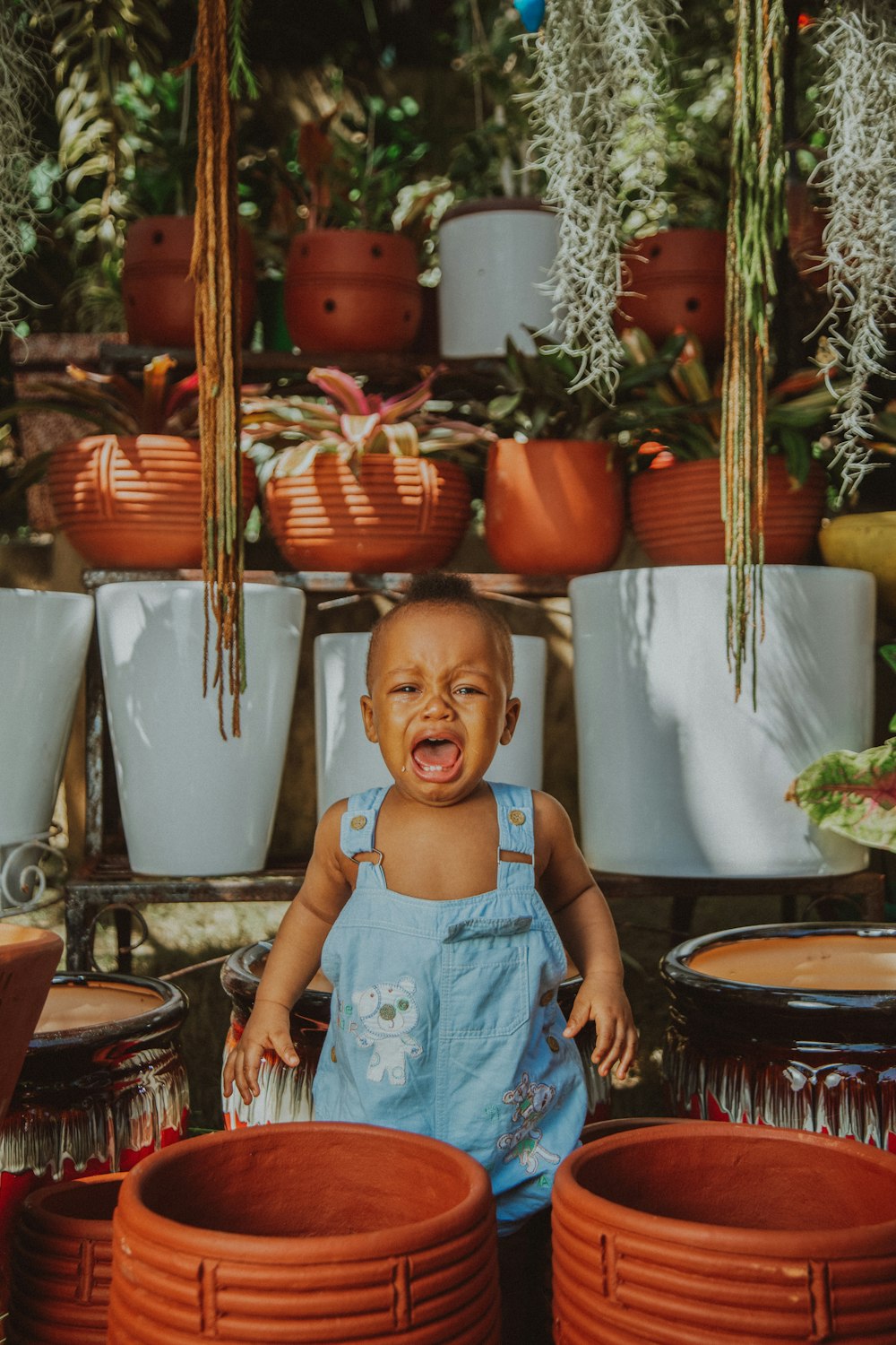 girl in blue tank top standing beside brown woven basket