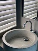 stainless steel faucet near window blinds