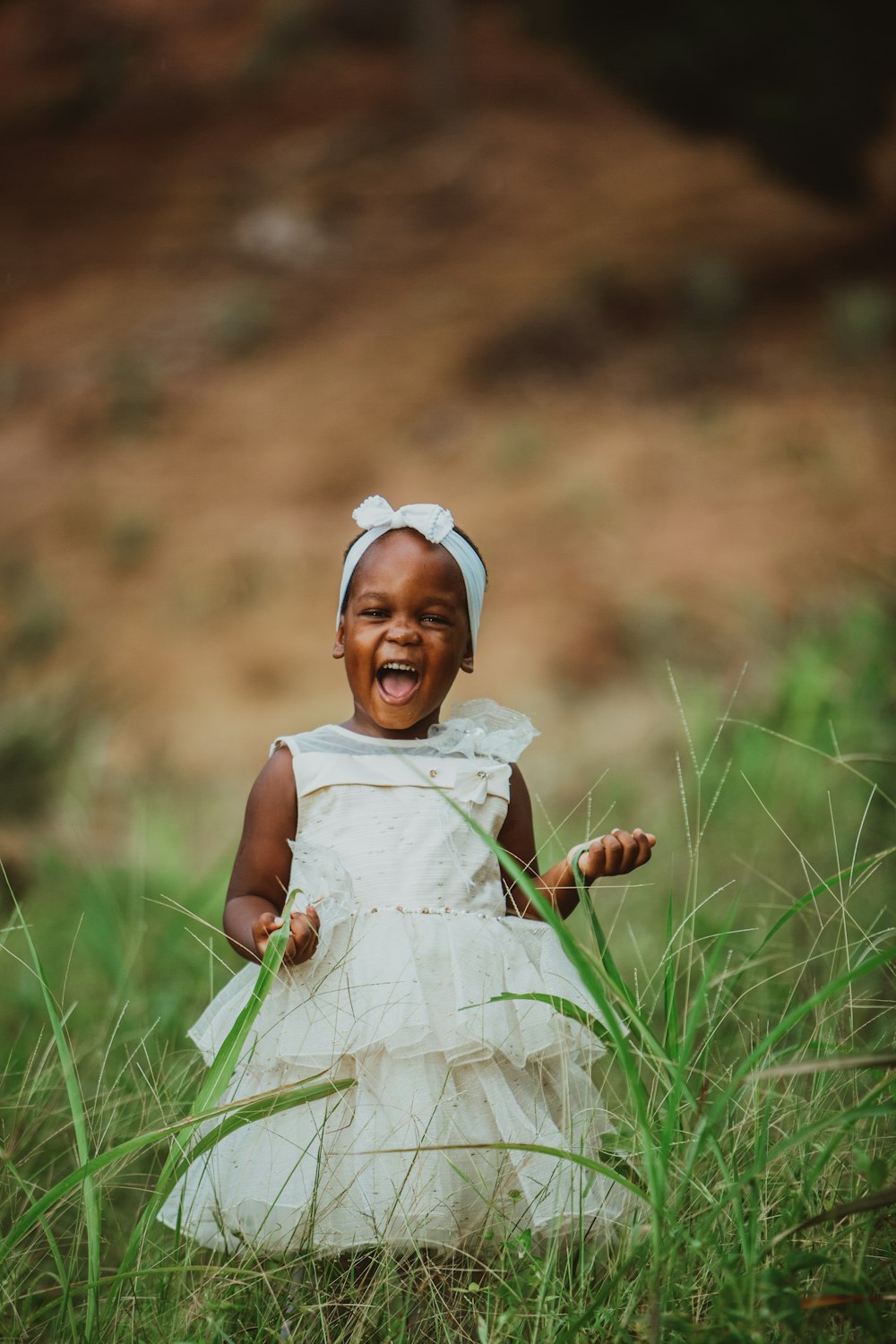 girl in white dress sitting on green grass during daytime