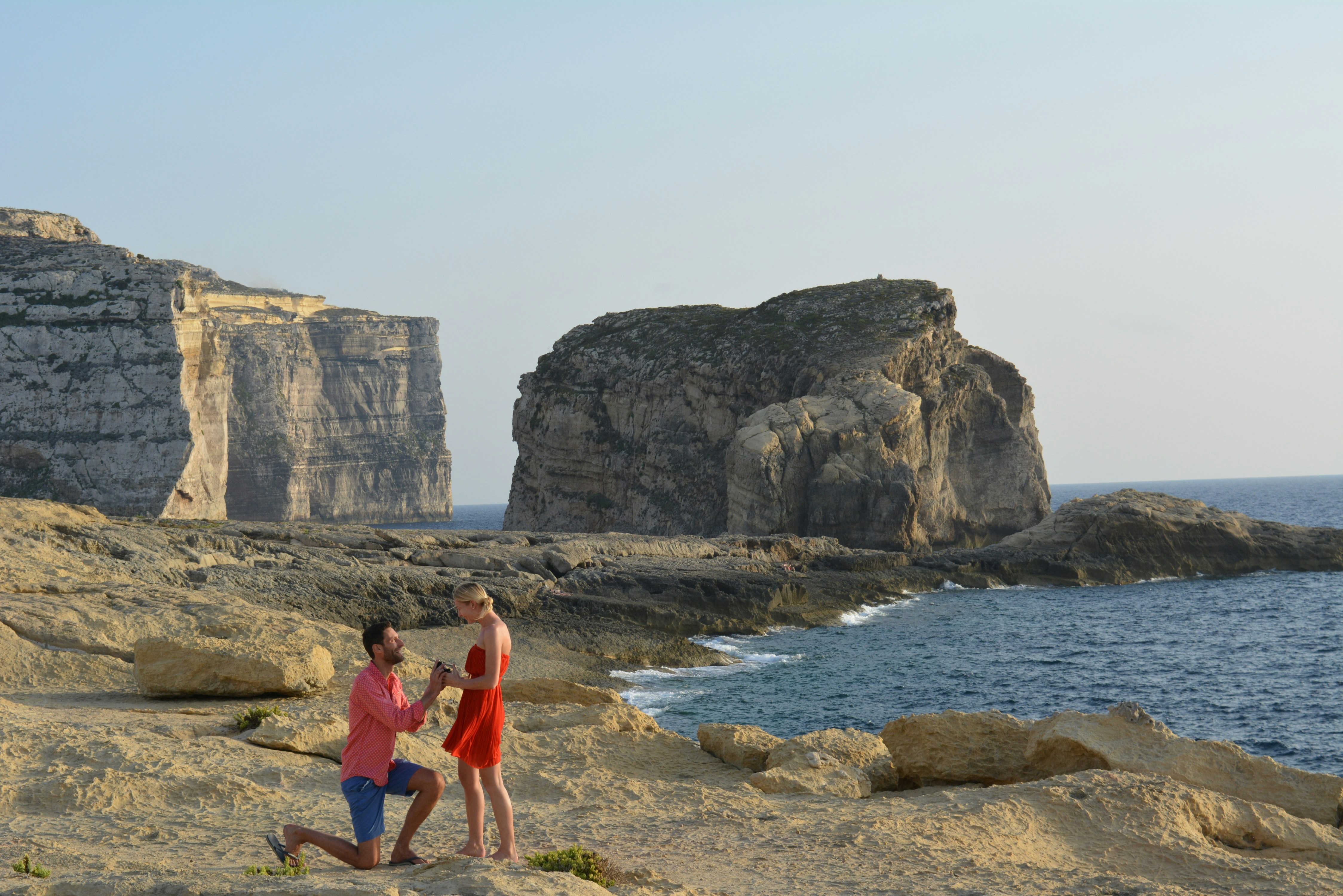 great photo recipe,how to photograph wedding proposal at sunset in malta; woman in red tank top standing on seashore during daytime