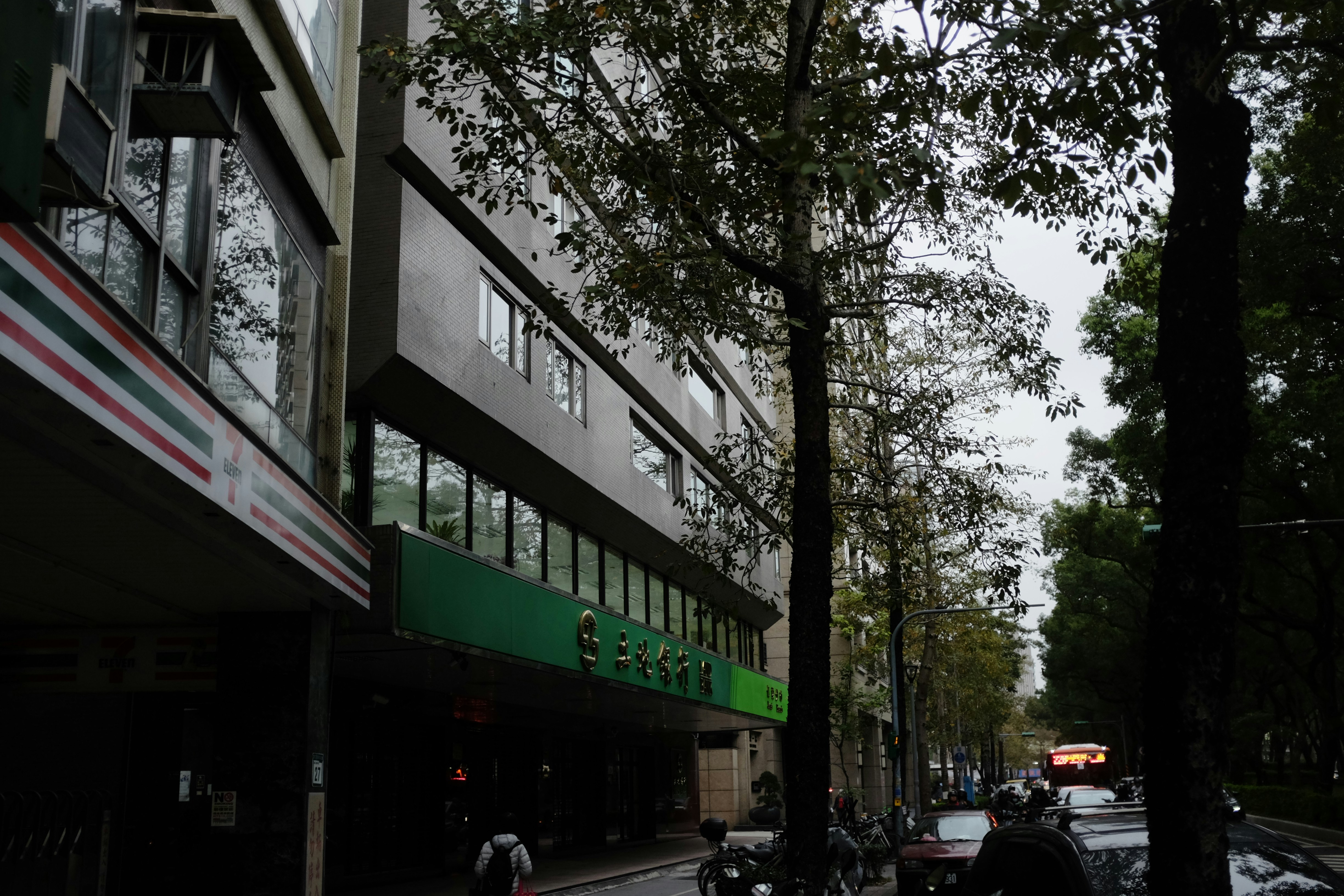 cars parked beside green trees and building during daytime