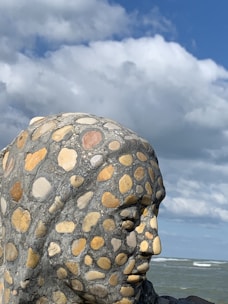 A finished granite sculpture displayed outdoors, showcasing its texture and form.