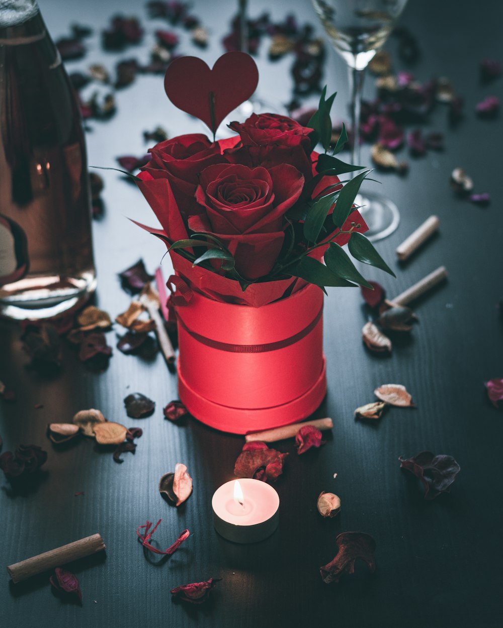 red rose in red ceramic vase