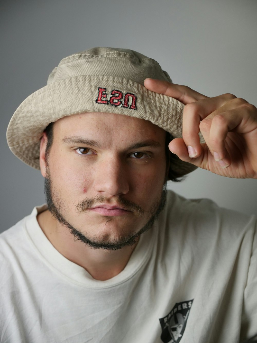 hombre con camisa blanca de cuello redondo con sombrero marrón