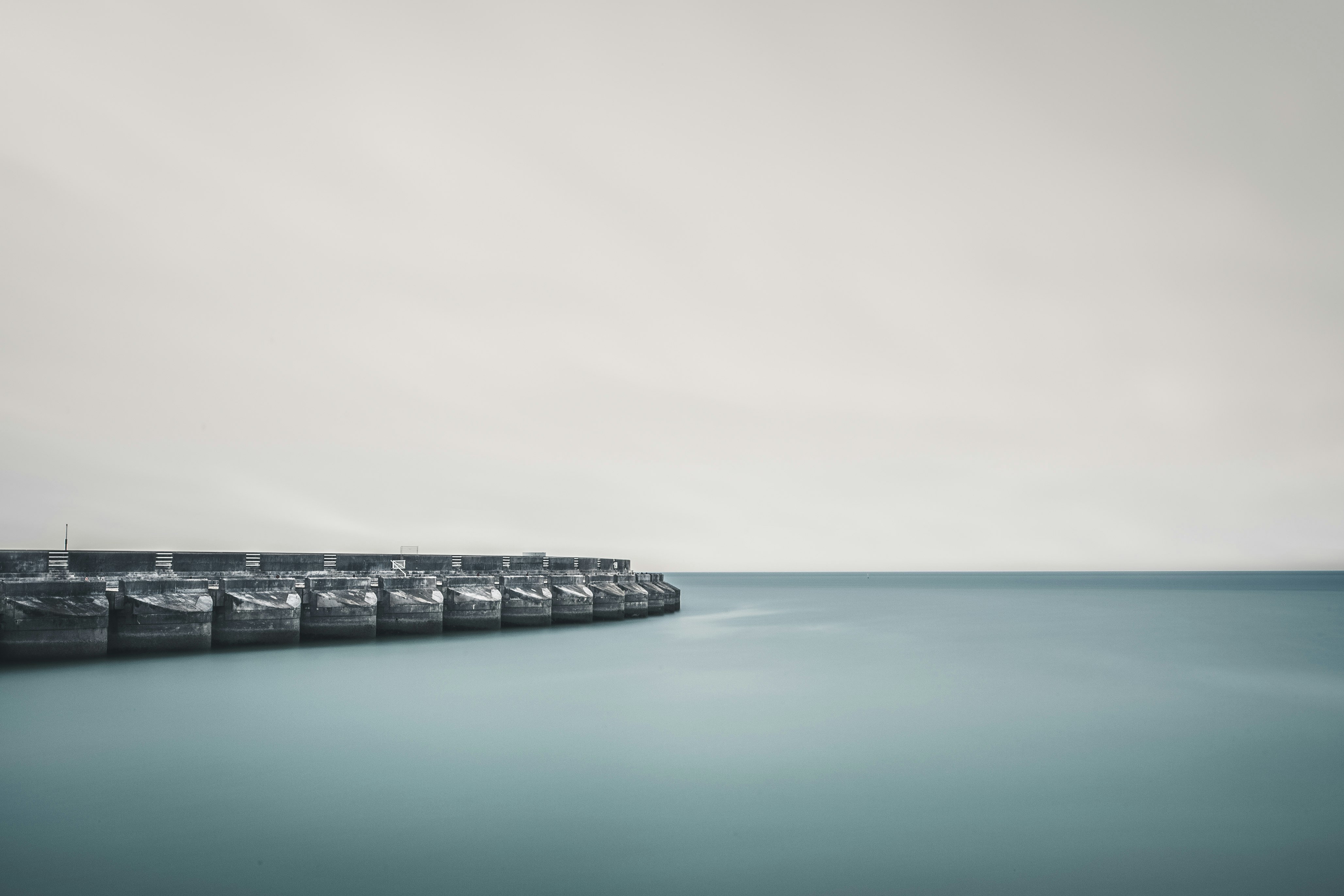 gray concrete dock on body of water during daytime