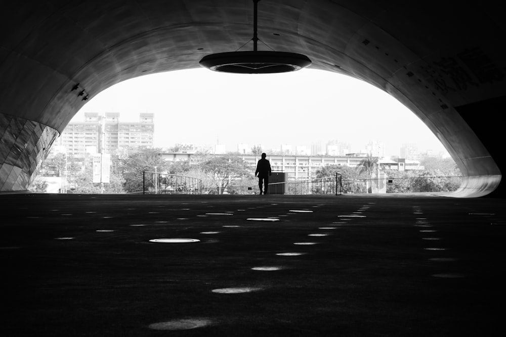 grayscale photo of man standing on road