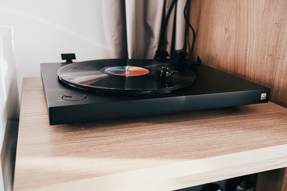 Tourne-disque vinyle noir sur table en bois marron