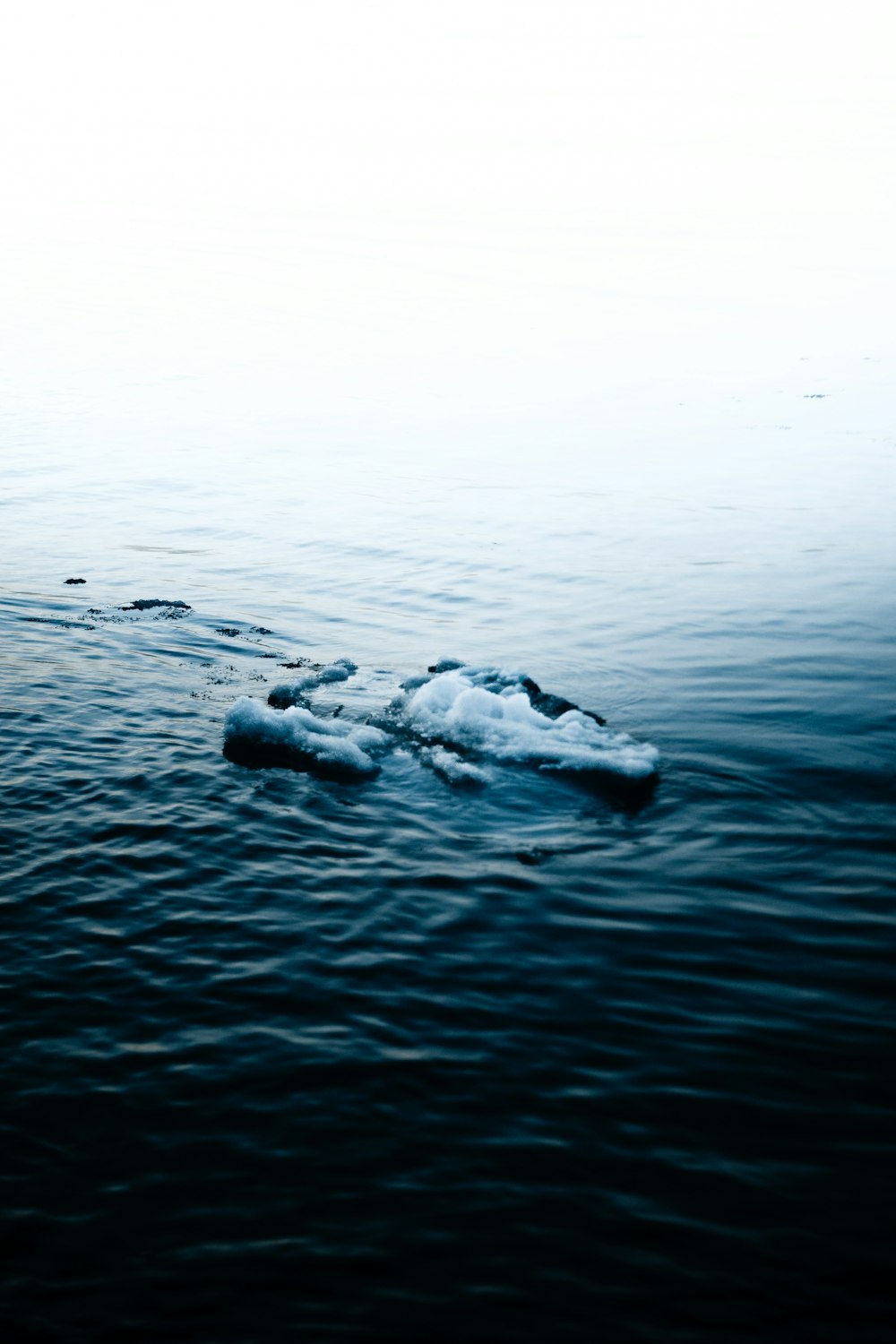 black rock on body of water during daytime