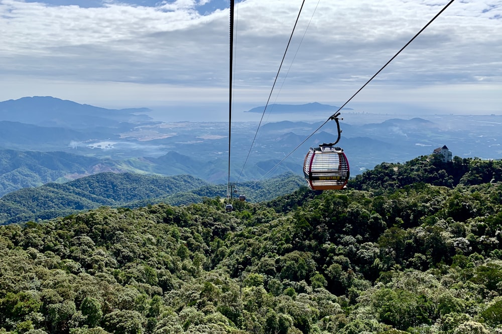 brown cable car over green mountains during daytime