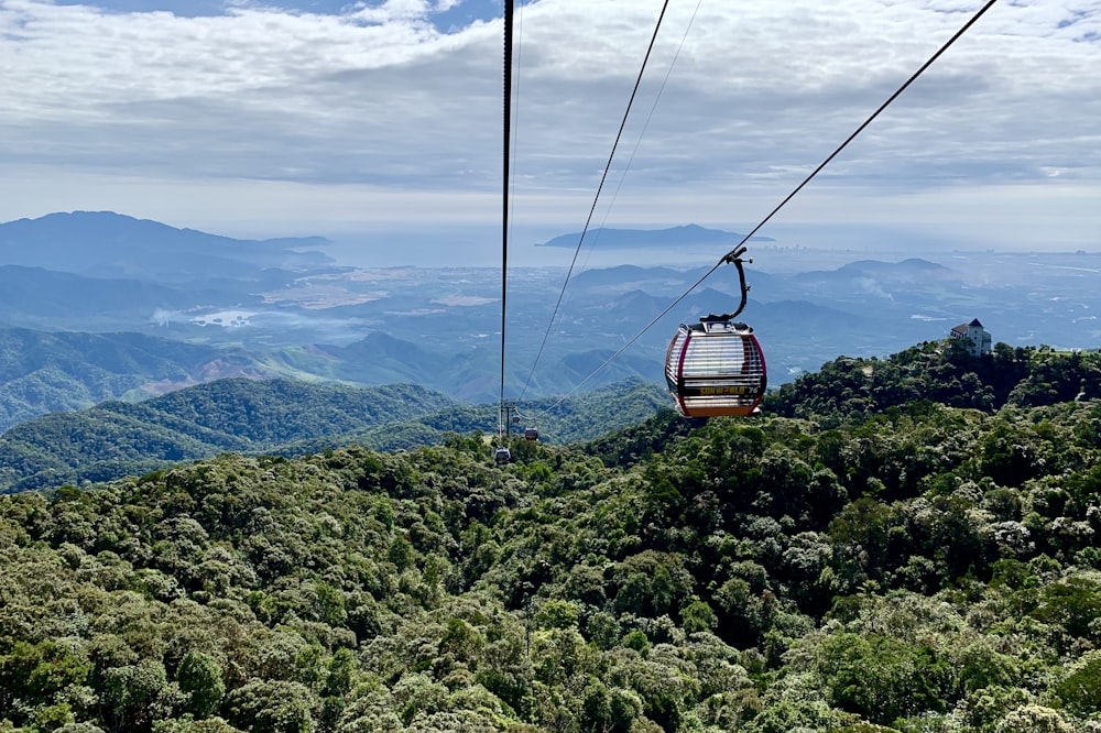 Braune Seilbahn über grüne Berge tagsüber