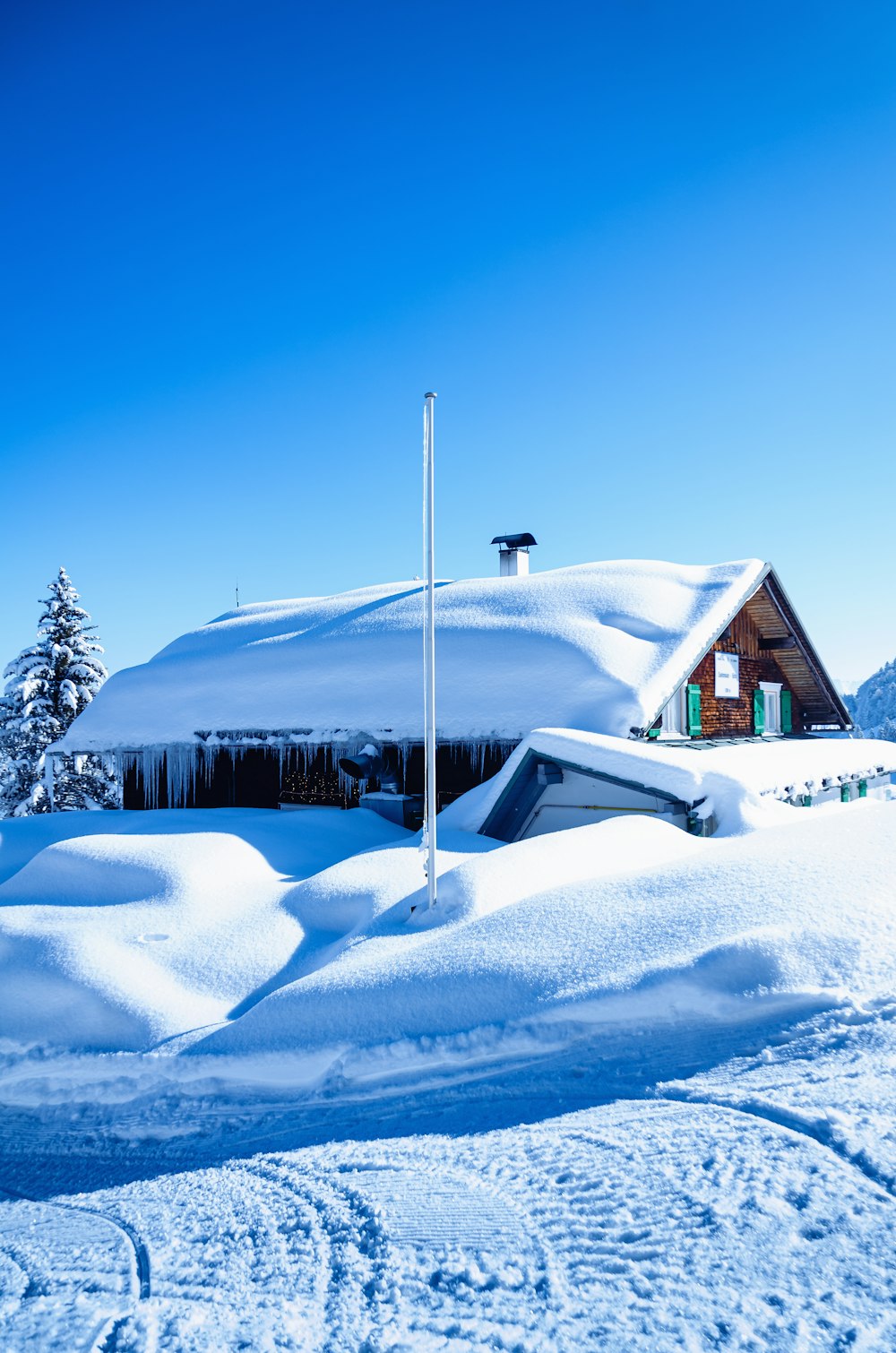 brown wooden house covered with snow during daytime