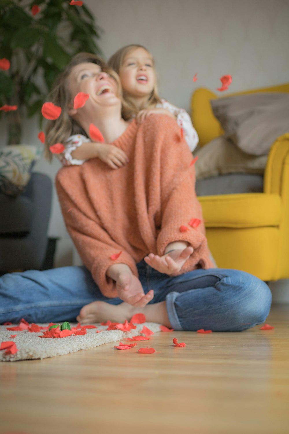 woman in pink sweater and blue denim jeans sitting on floor