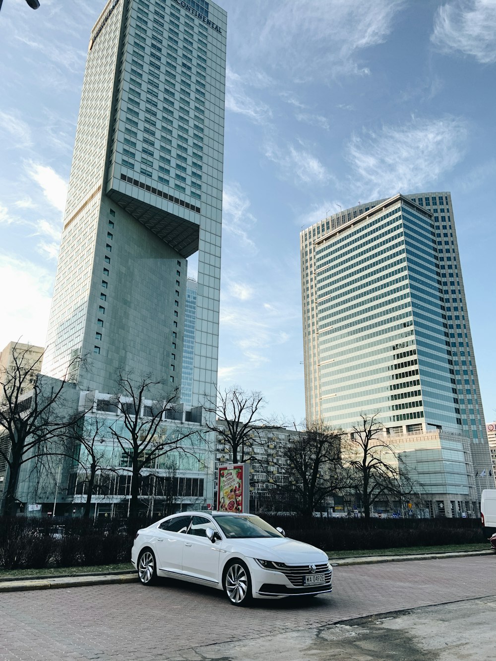 a white car parked in front of two tall buildings