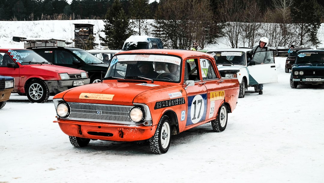 orange and white vintage car on snow covered ground