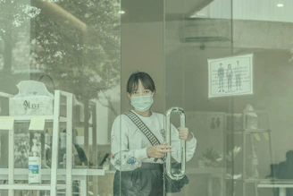 Close-up of a cleaner wearing gloves and mask, disinfecting a door handle.