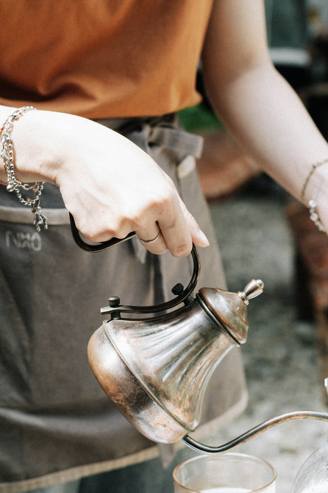 person holding stainless steel teapot