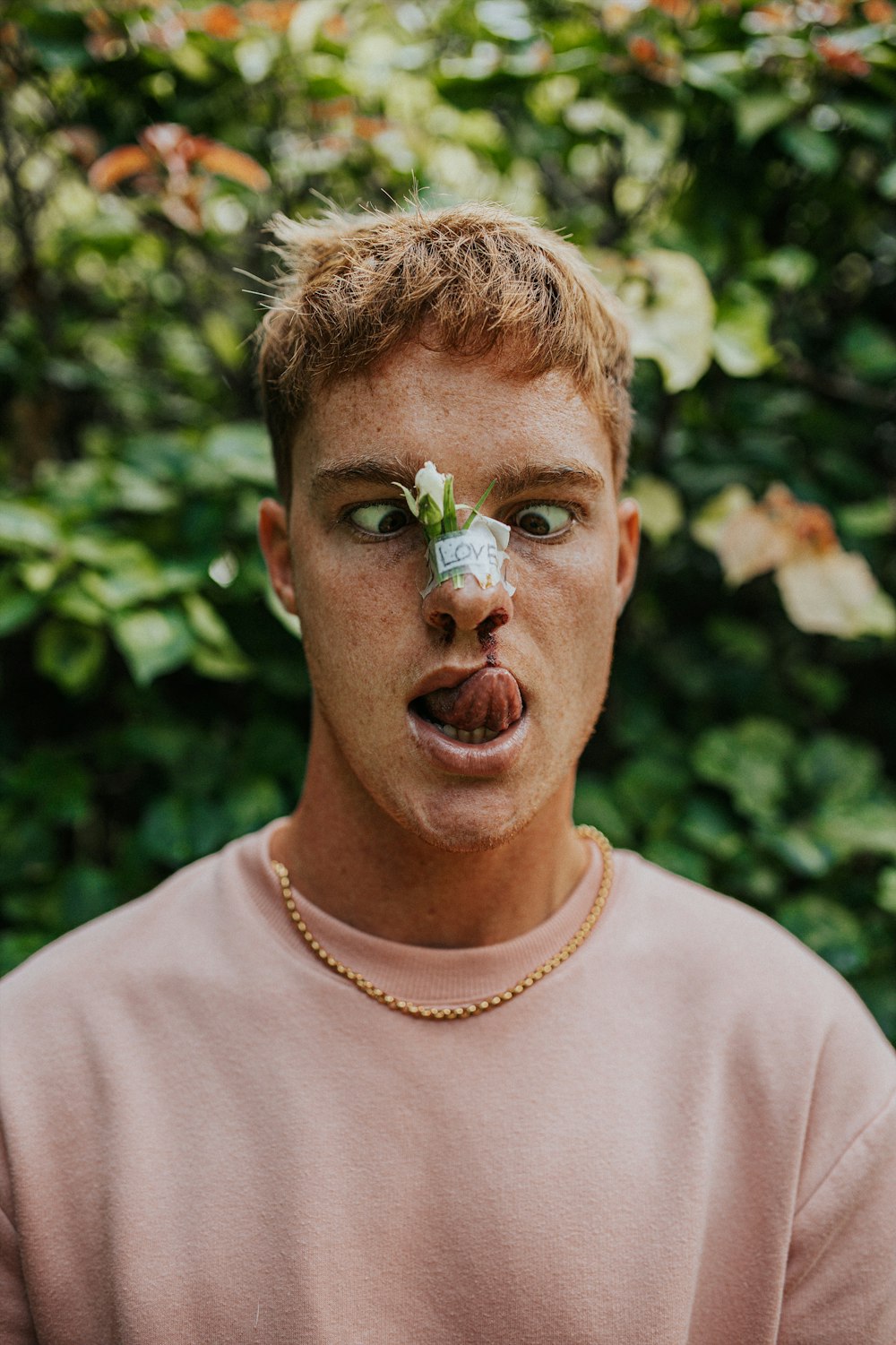 man in white crew neck shirt with white flower on his mouth