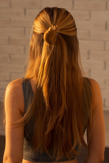 woman in black tank top with brown hair tie