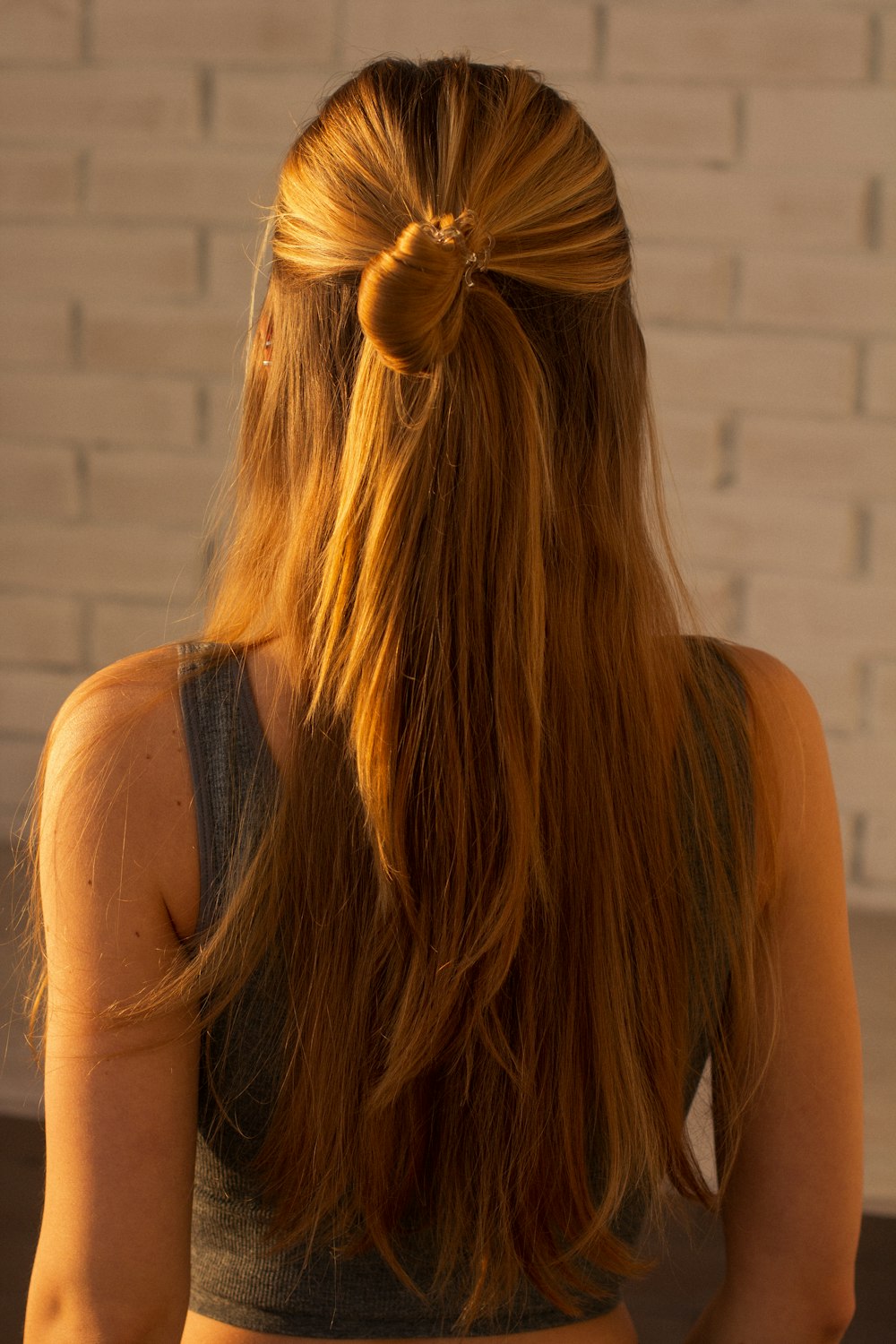 woman in black tank top with brown hair tie