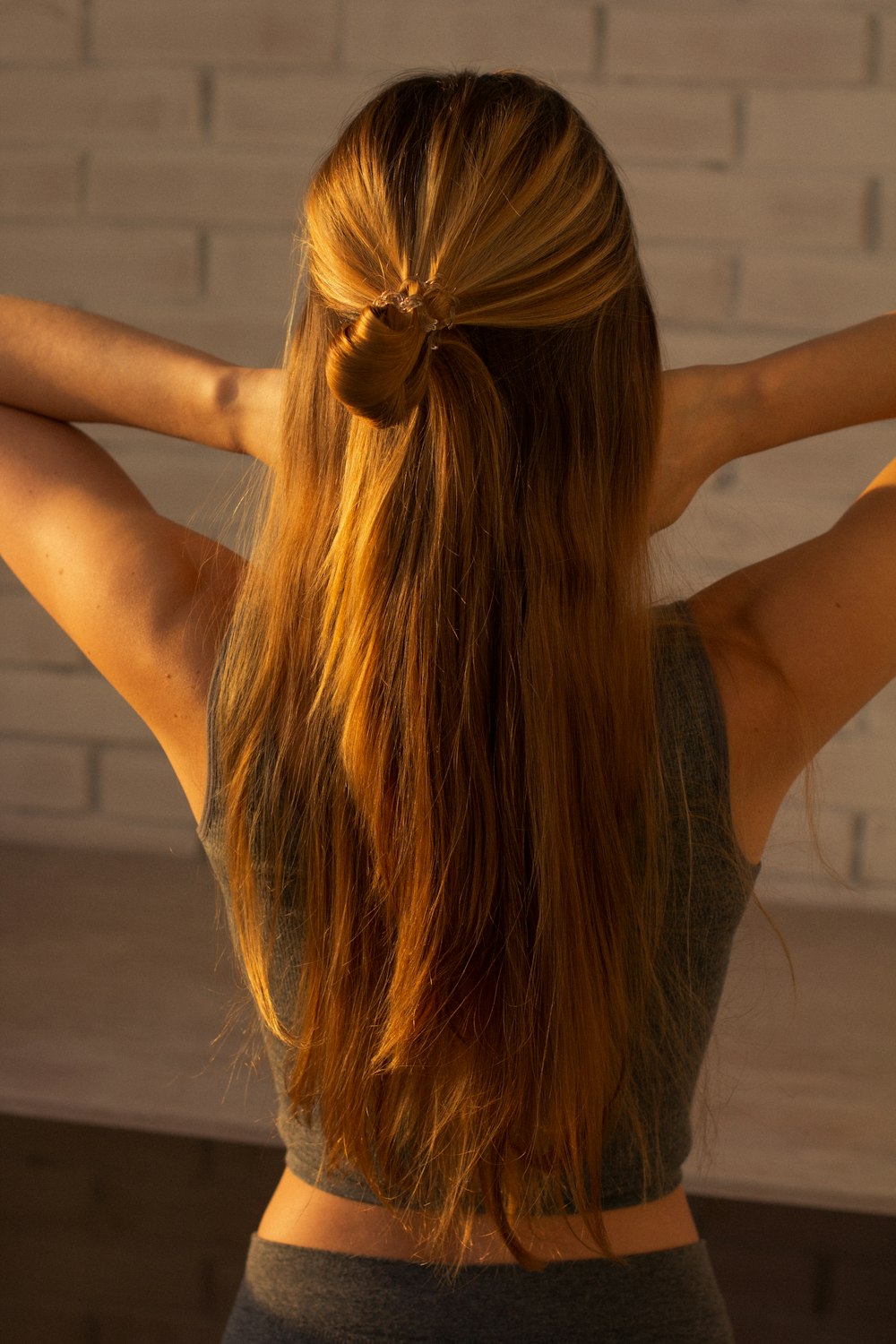 woman in black tank top raising her hands