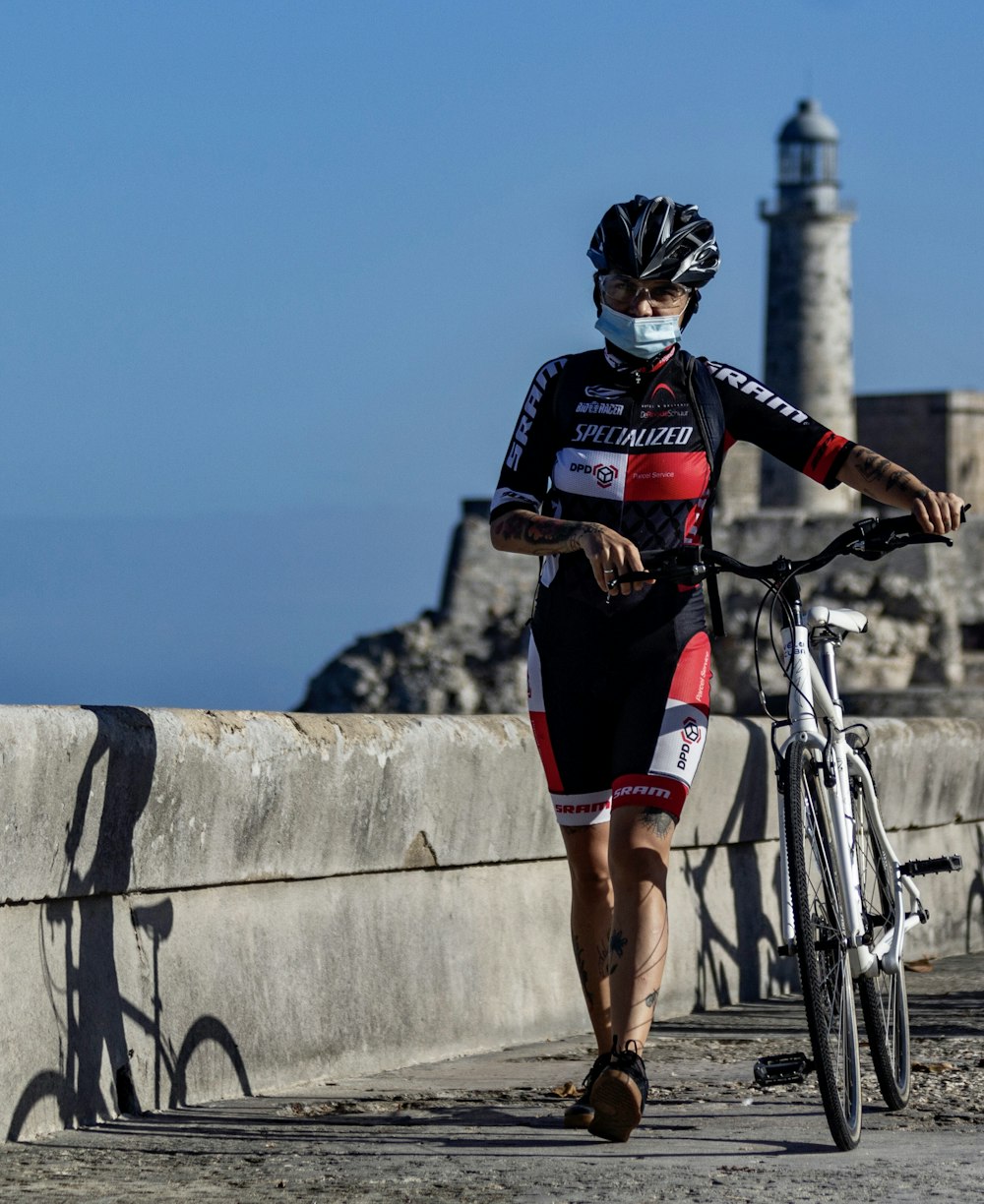 man in black and white shirt and red shorts riding blue bicycle during daytime