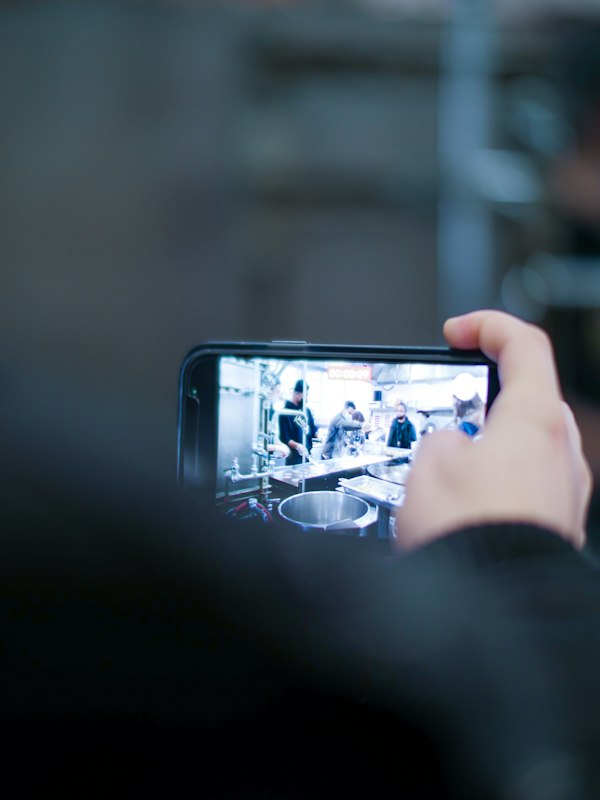 Persona grabando con su teléfono el interior de un taller industrial en funcionamiento, el material real que necesita una agencia de tiktok ads para empresas