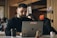 man in black crew neck shirt using macbook