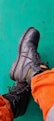 person wearing black leather work boot