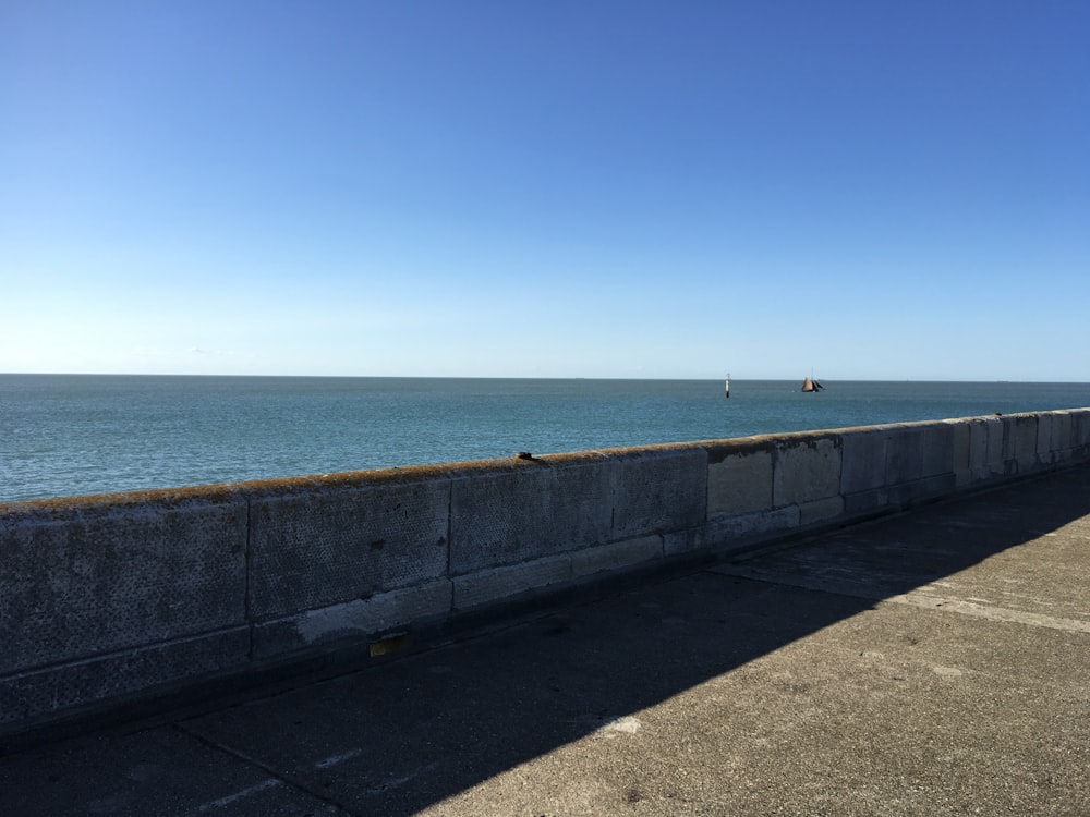 gray concrete wall near sea during daytime